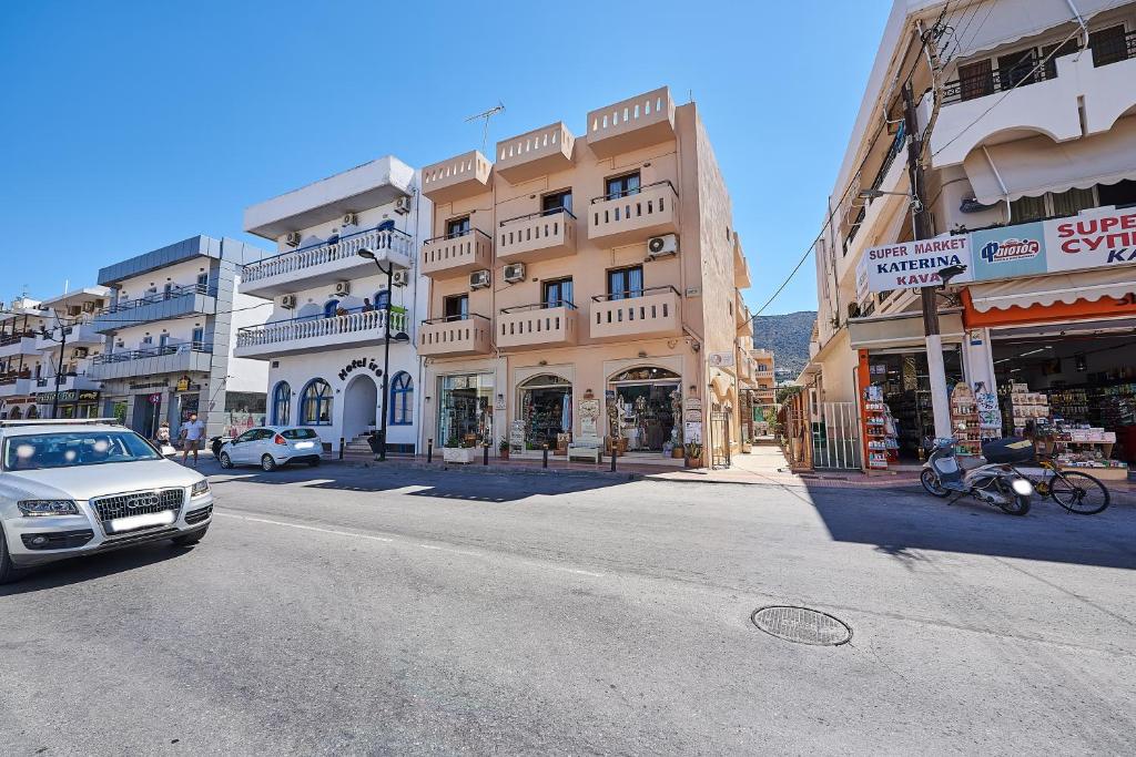a city street with cars parked in front of buildings at Thalia deco City & Beach Hotel in Hersonissos