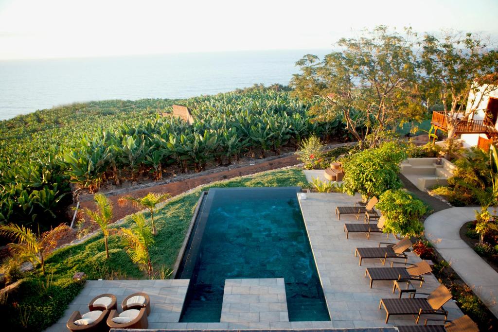 una vista aérea de la piscina, las sillas y el océano en Hacienda Cuatro Ventanas en Los Realejos