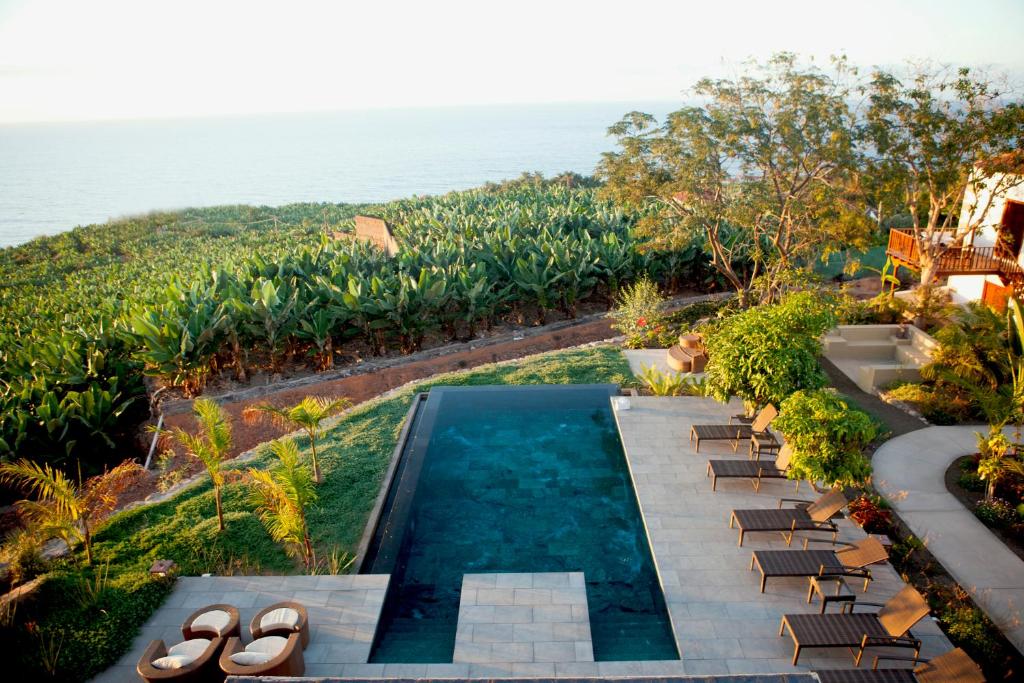 an aerial view of a swimming pool and chairs and the ocean at Hacienda Cuatro Ventanas in Los Realejos