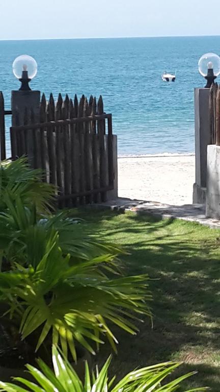 a fence on the beach with a boat in the water at Bed & Breakfast T.T in Río Hato