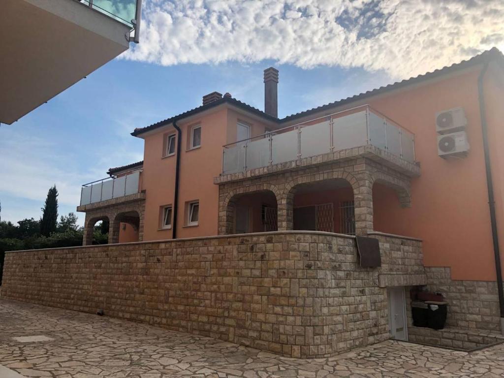 une grande maison avec un mur en briques dans l'établissement Villa Luka, à Barbariga