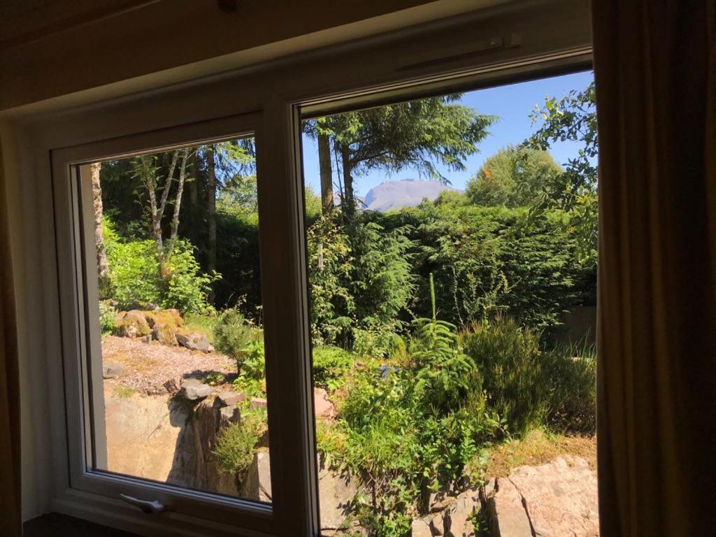 a window with a view of a garden outside at TOM BEAG - Ben Nevis view ROOMS in Fort William