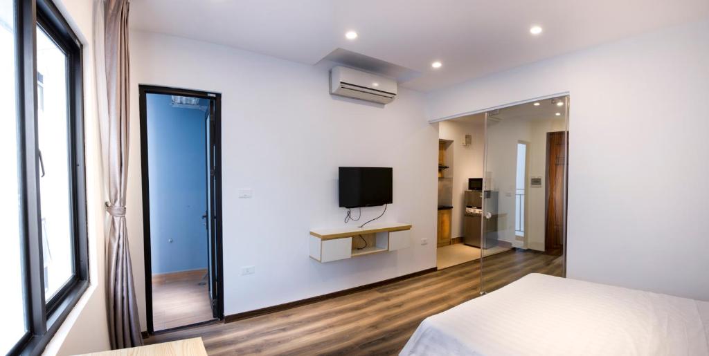 ein Schlafzimmer mit einem Spiegel und einem TV an der Wand in der Unterkunft Era Apartment Nguyen Van Huyen in Hanoi