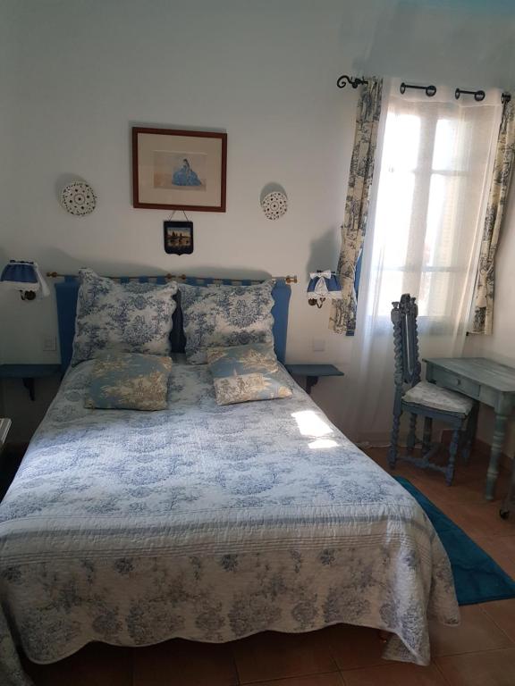 1 dormitorio con cama, mesa y ventana en Hôtel Restaurant L'Aiglon, en Zonza