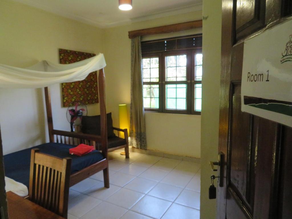 a room with a bedroom with a bed and a window at Bikeventures House Uganda in Jinja