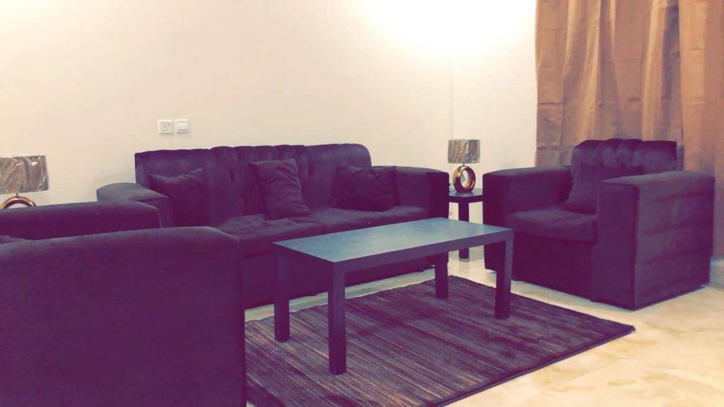 艾卜哈的住宿－Al Sondos Furnished Apartments，客厅配有紫色沙发和桌子