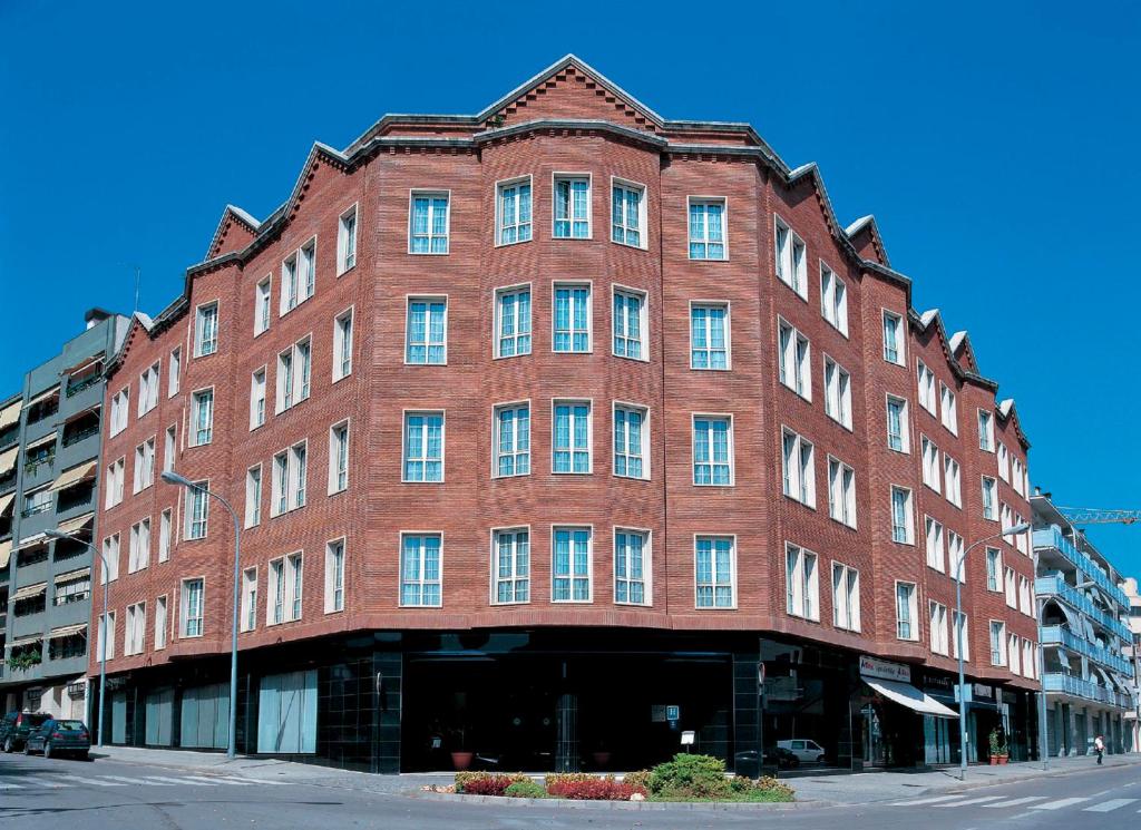 un grand bâtiment en briques rouges dans une rue de la ville dans l'établissement URH Ciutat de Mataró, à Mataró