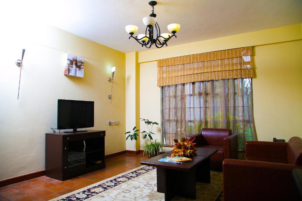 a living room with a couch and a television at Batians Apartment Hotel in Nairobi