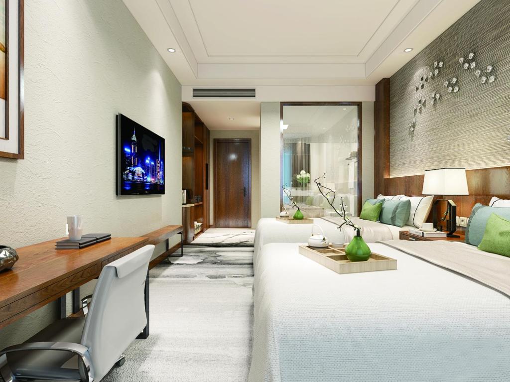 sala de estar con 2 camas blancas y escritorio en Fu Hua International Hotel Dunhuang, en Dunhuang