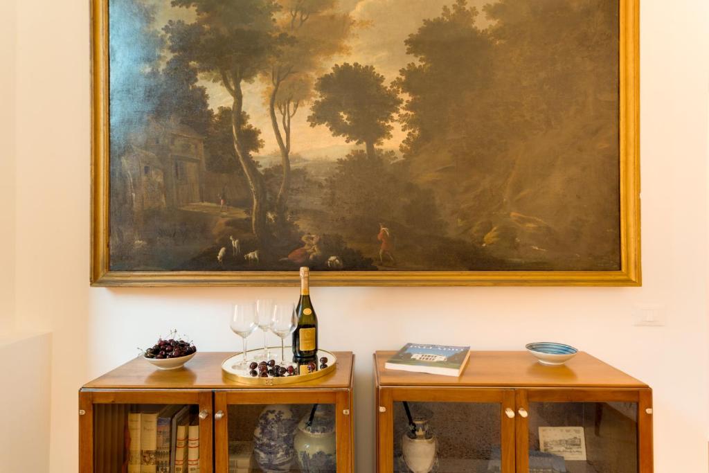 a painting on the wall with a bottle of wine and two tables at Ca' Dorina Luxury in Venice