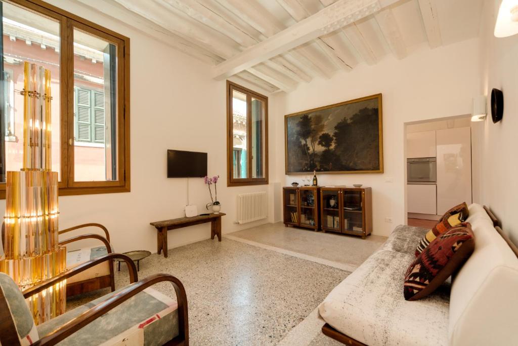 uma sala de estar com um sofá e uma televisão em Ca' Dorina Luxury em Veneza