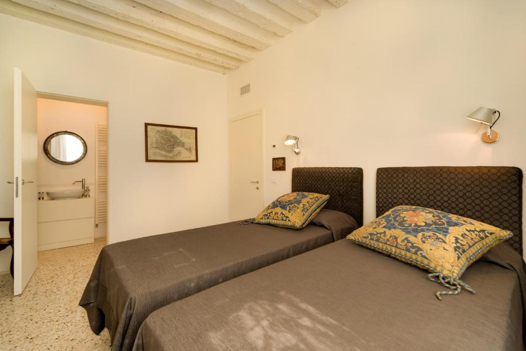a bedroom with two beds in a room at Ca' Dorina Luxury in Venice