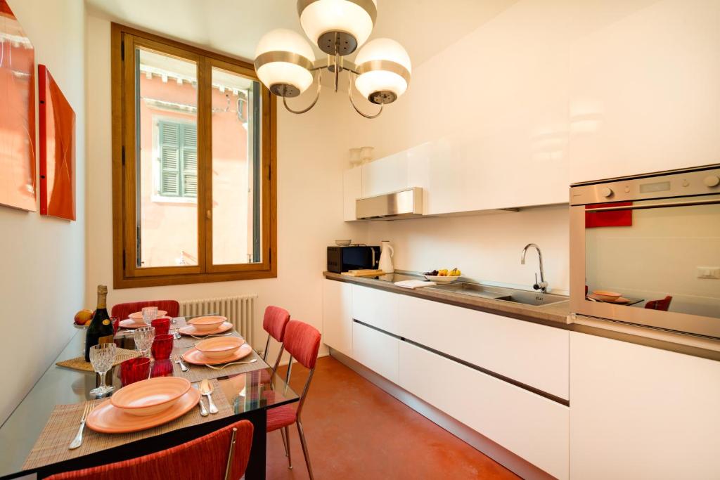 a kitchen with a table with red chairs and a sink at Ca' Dorina Luxury in Venice