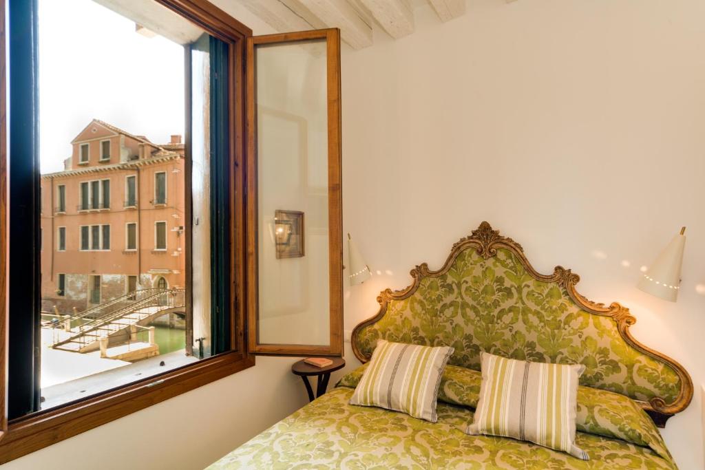 a bedroom with a bed and a large window at Ca' Dorina Luxury in Venice
