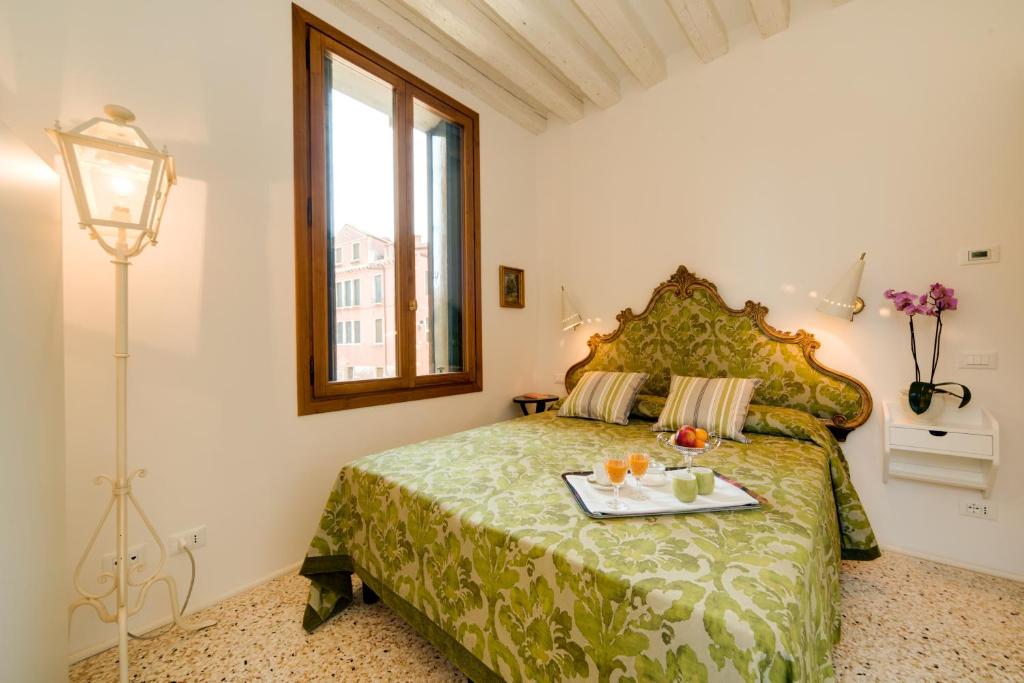 a bedroom with a bed with a tray of food on it at Ca' Dorina Luxury in Venice