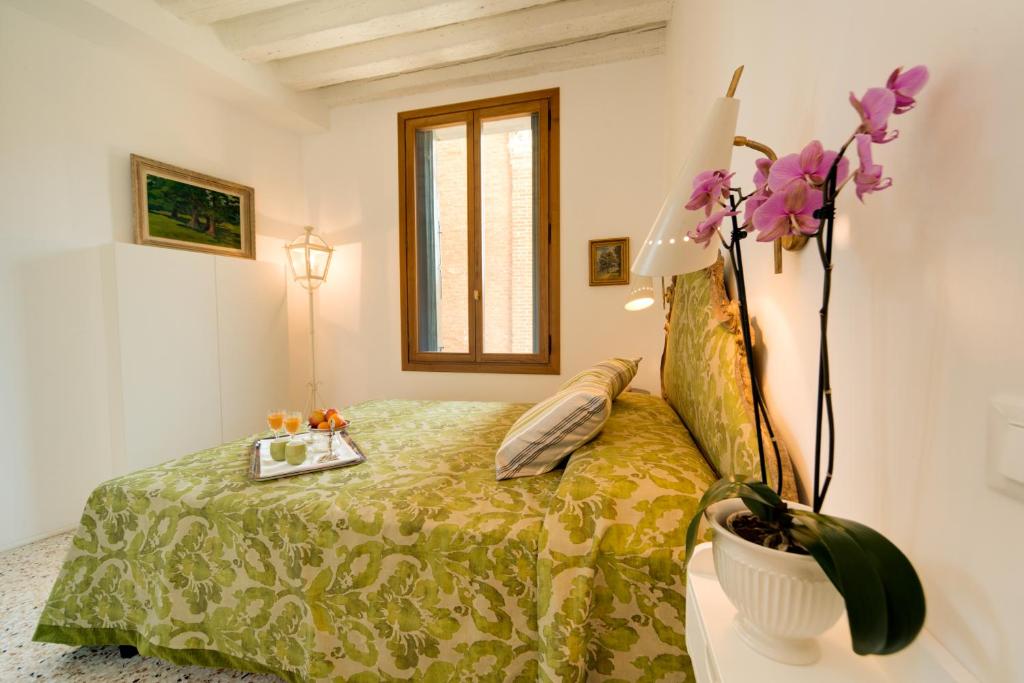 a bedroom with a bed and a vase with flowers at Ca' Dorina Luxury in Venice
