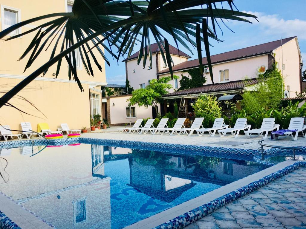 una piscina con sillas y un hotel en Hotel Oasis, en Nikolaevka