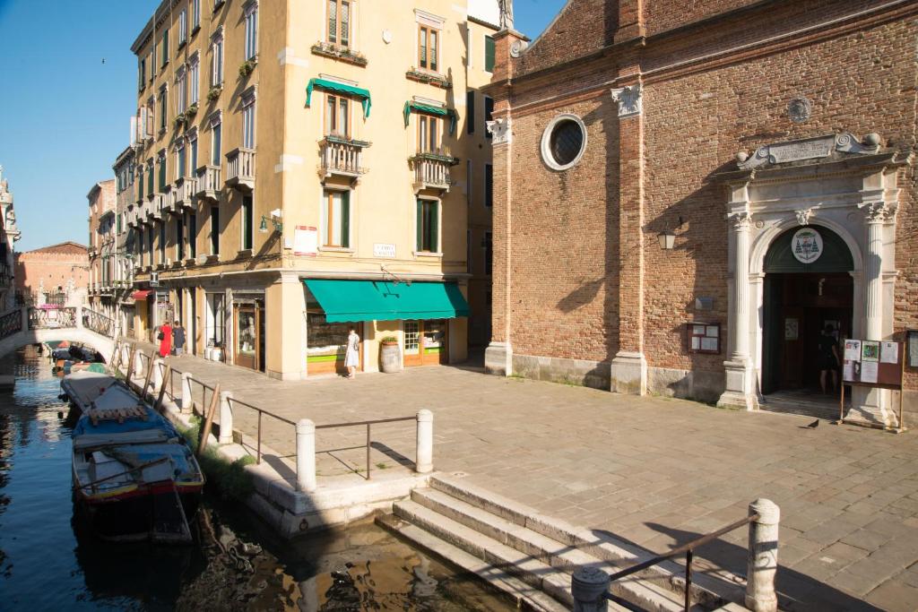 a group of buildings next to a canal with a boat at Ca' Dorina Luxury in Venice