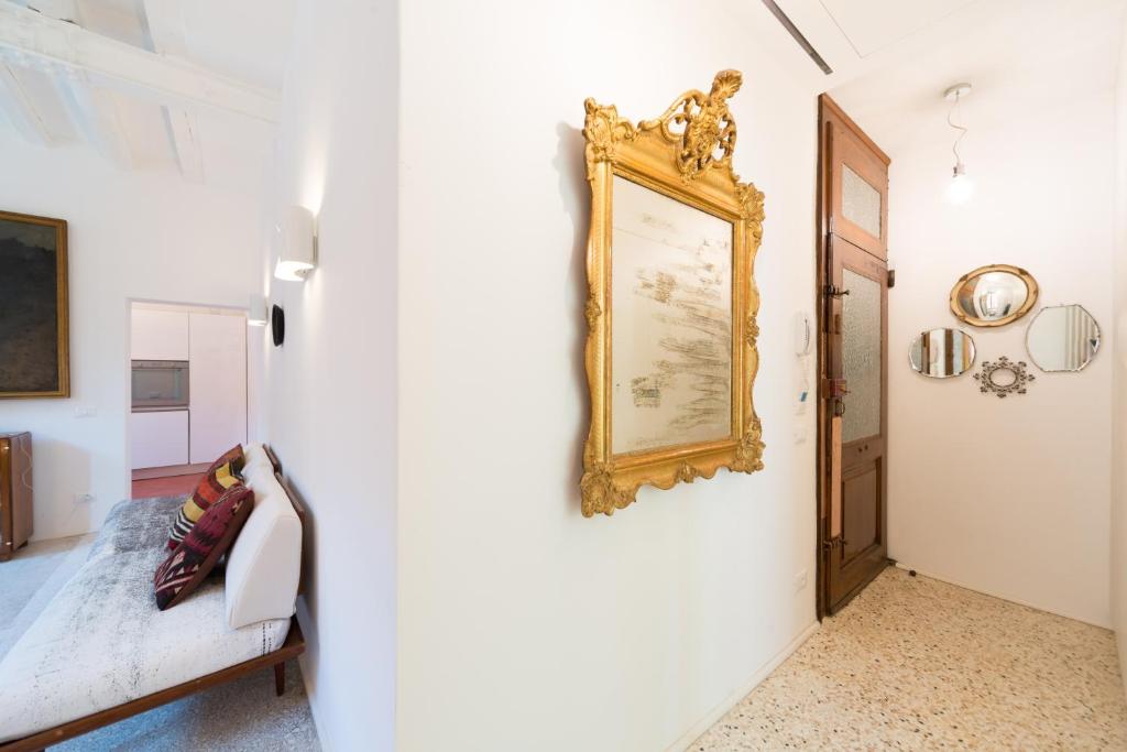 a room with a white wall with a gold picture on the wall at Ca' Dorina Luxury in Venice