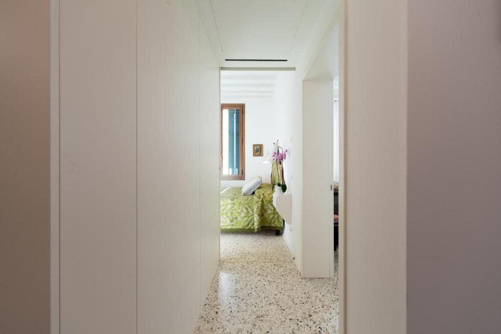 a hallway with white walls and a room with a bed at Ca' Dorina Luxury in Venice