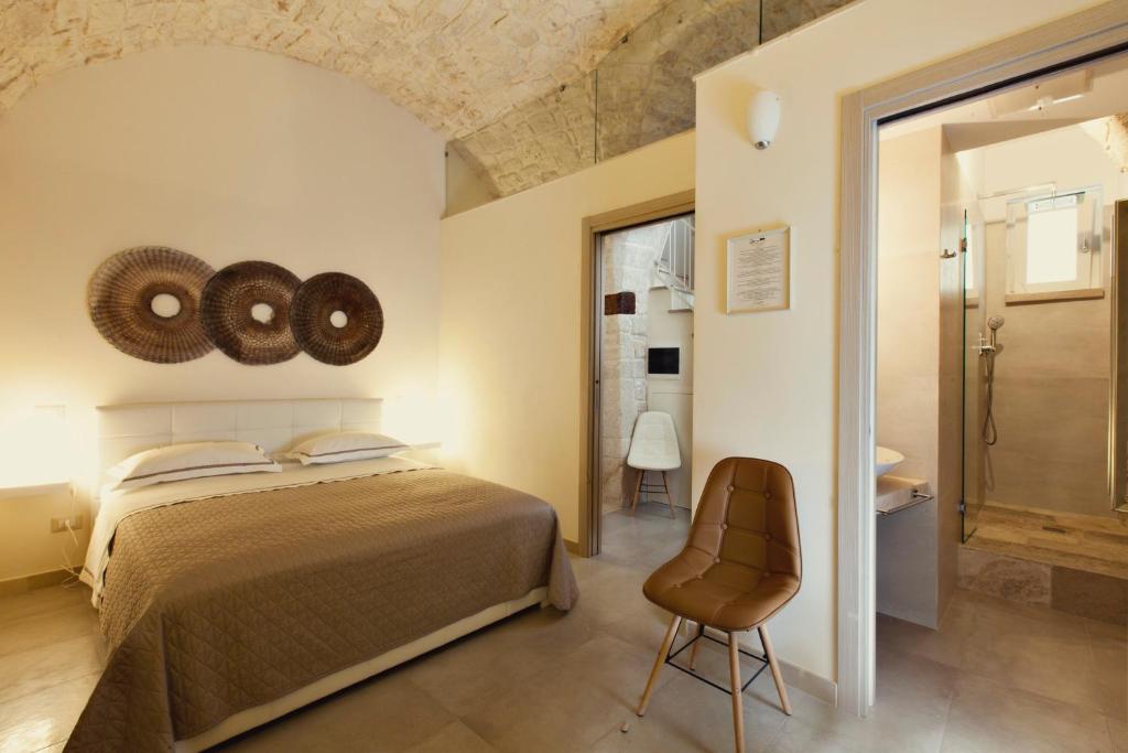 コンヴェルサーノにあるDimora a Corteのベッドルーム1室(ベッド1台、椅子付)