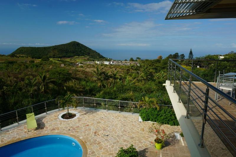 a balcony of a house with a view of a hill at Les Nymphes De Bourbon in Saint-Pierre