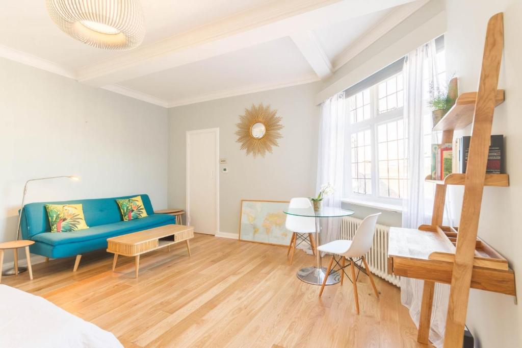 sala de estar con sofá azul y mesa en Chic 1 Bed Studio Flat in Popular Bloomsbury en Londres
