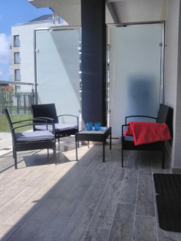 a group of chairs and tables on a balcony at Apartament niebieski w kompleksie 5 Morz in Sianozety