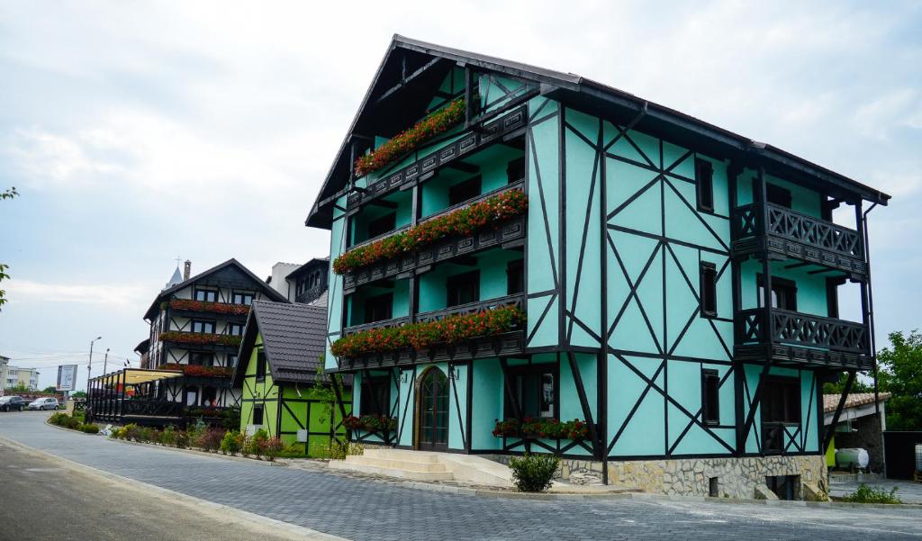 a building with balconies on the side of a street at Vila Alsace Podu' cu Lanturi in Bacău