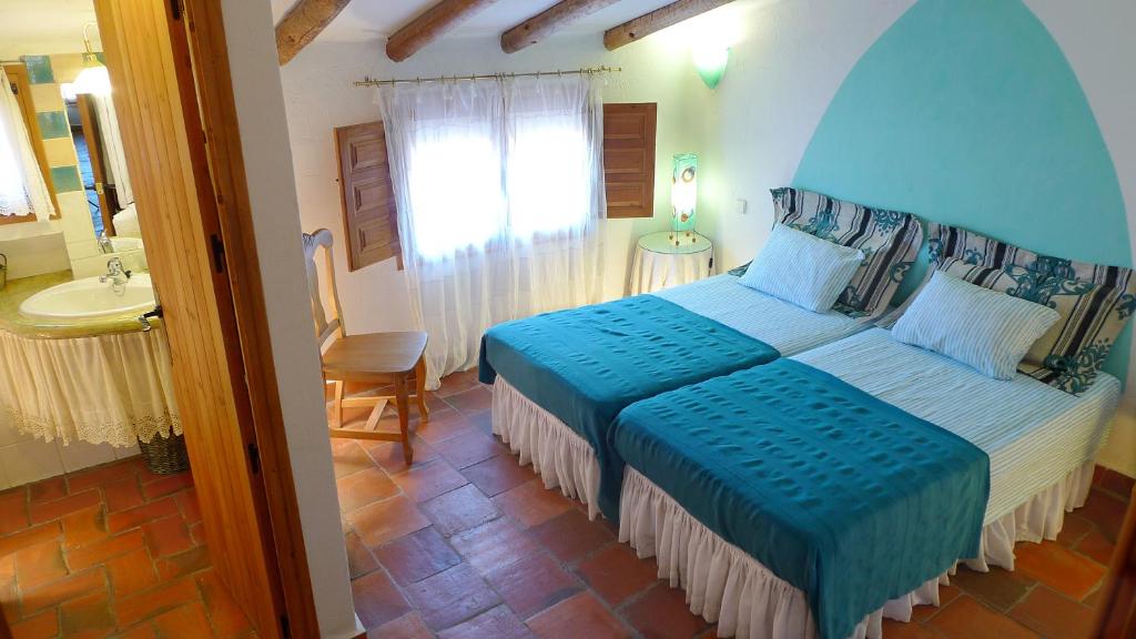 1 dormitorio con 1 cama grande y lavamanos en Casa rural El Pinche, en Espinoso del Rey