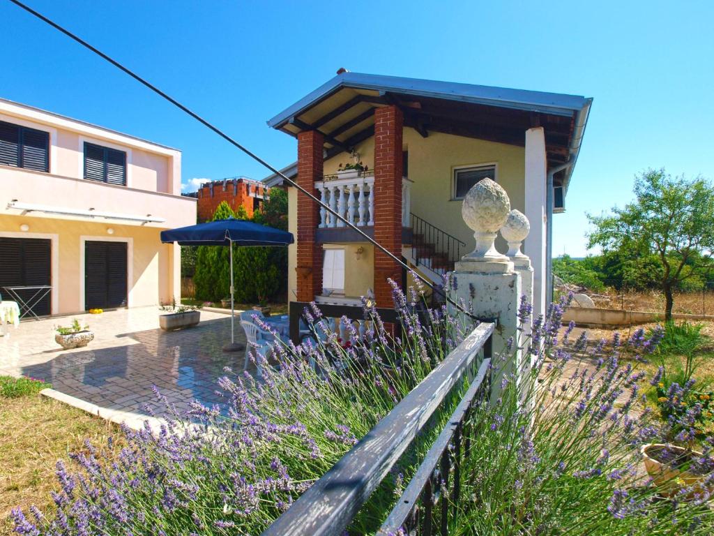 a house with a fence and purple flowers at Apartments Milica 1391 in Banjole
