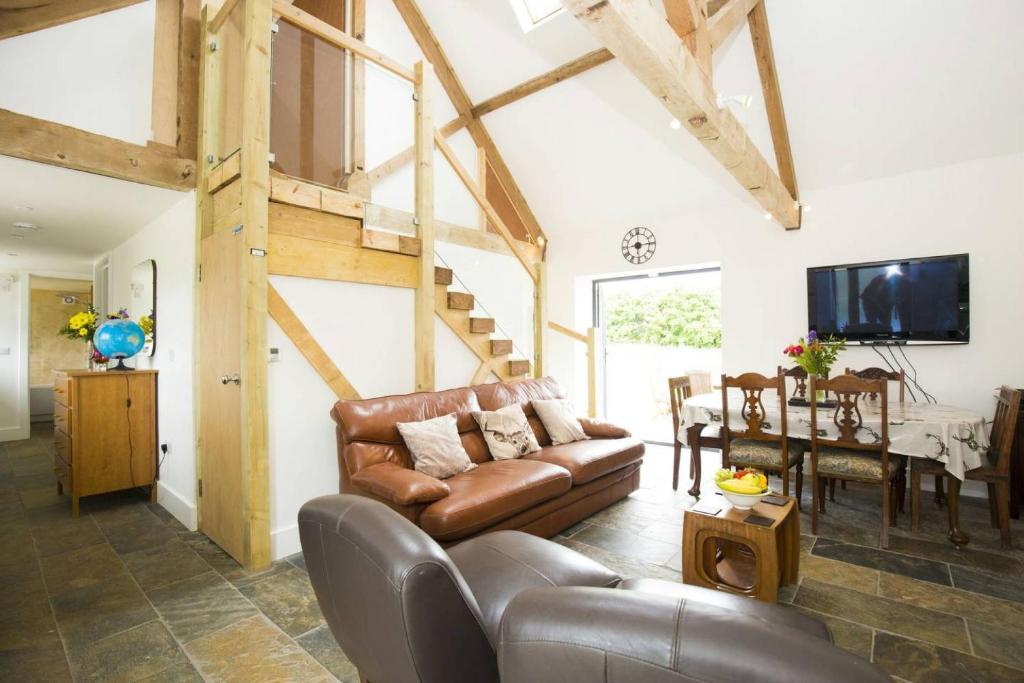 a living room with a leather couch and a table at North cottage · Country retreat in the heart of Sussex -Twineham in Twineham