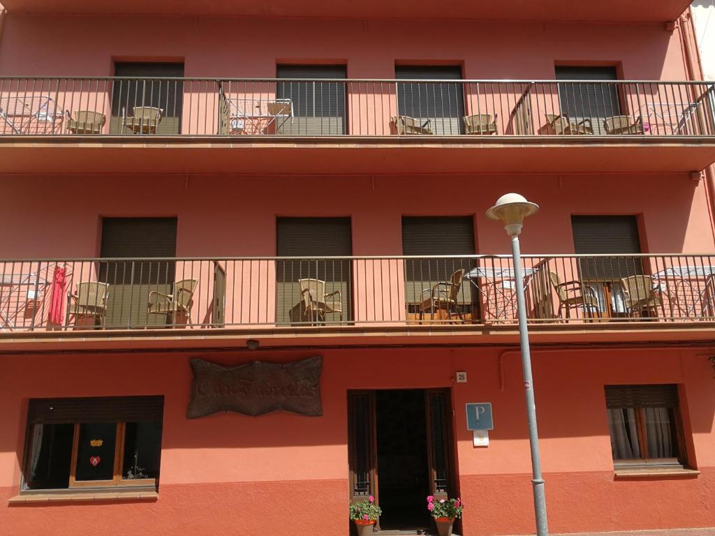 un bâtiment avec des chaises et des tables sur le balcon dans l'établissement Pensio Can Fabrellas, à Sant Antoni de Calonge