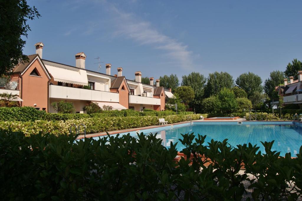 un resort con piscina di fronte a un edificio di Appartamenti Nuovo Sile a Cavallino-Treporti