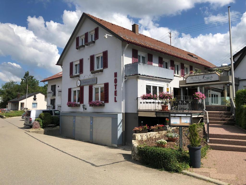 una casa blanca con persianas rojas en una calle en Hotel Heuberger Hof, Wehingen en Wehingen