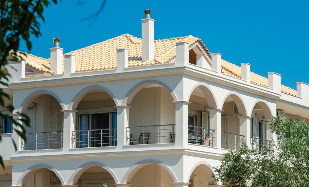 a large white house with a balcony at Villa Penelope in Kalpaki
