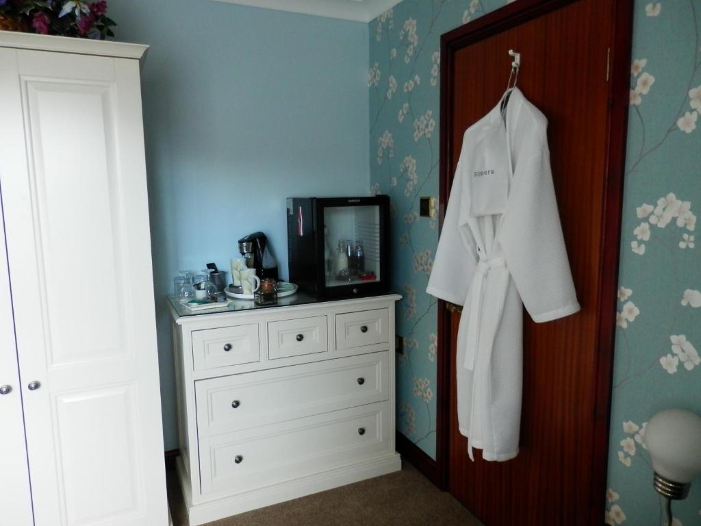 a bedroom with a white dresser and a mirror at Finjaro in Sproughton
