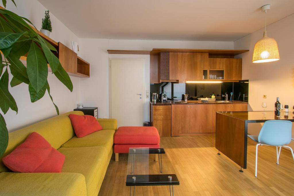a living room with a couch and a kitchen at Flataid Apartment Schießstattgasse in Graz