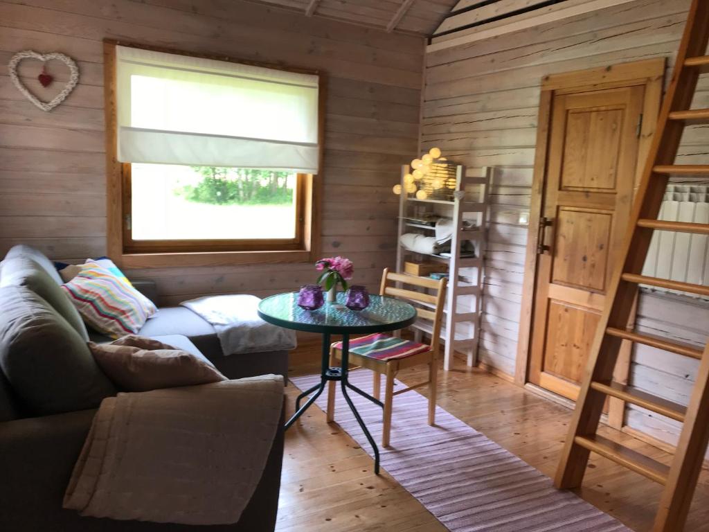 een woonkamer met een bank en een tafel bij Laasi Cozy Cottage in Kaigutsi
