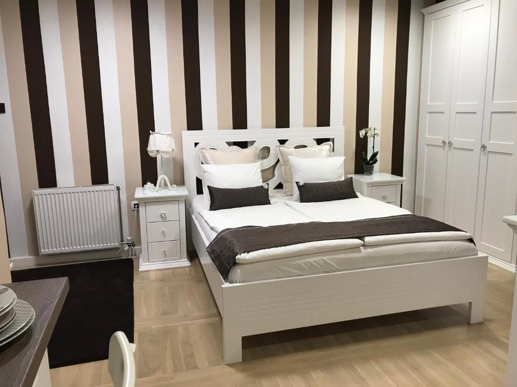 a bedroom with a bed with black and white stripes at Lux new white apartment in Novi Sad