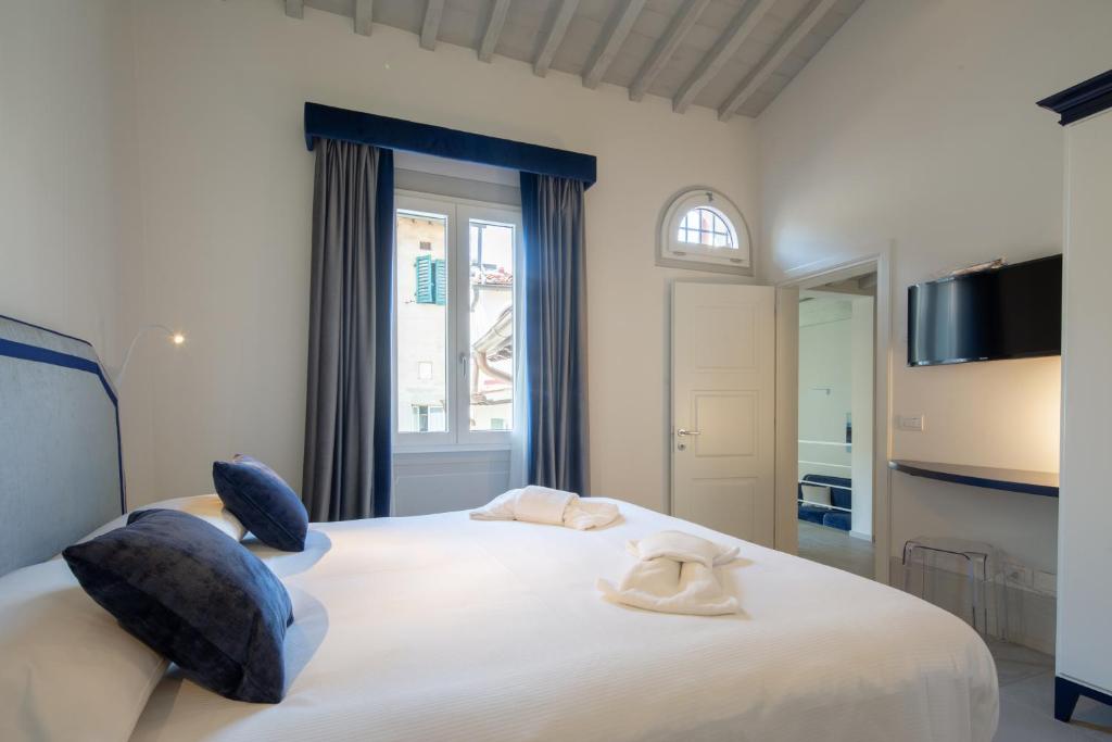 a bedroom with a large white bed with blue pillows at Carapelli Apartments in Florence