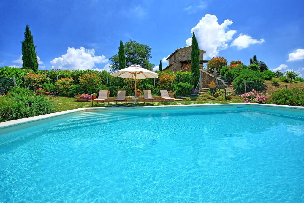 a swimming pool in front of a house at Castelmuzio by PosarelliVillas in Castelmuzio