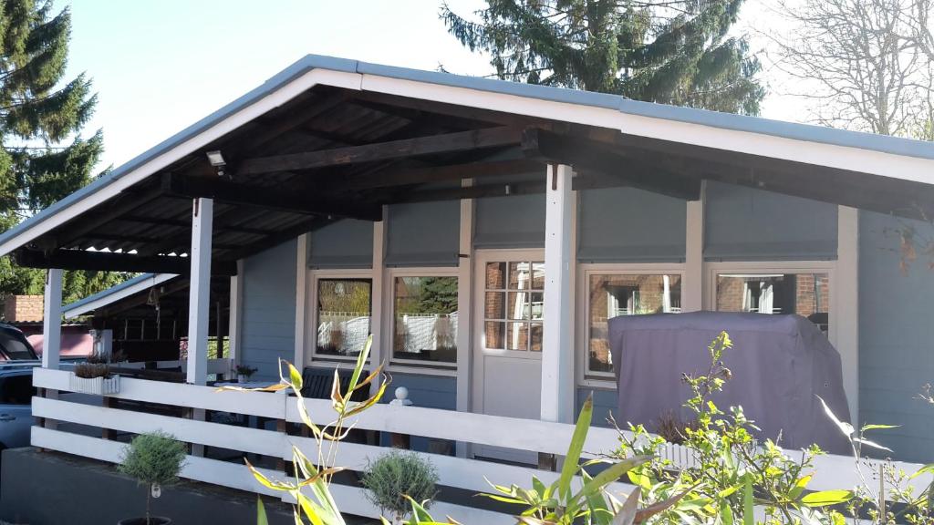 Cette petite maison blanche dispose d'une terrasse couverte. dans l'établissement Ferienhaus Leja, à Beschendorf