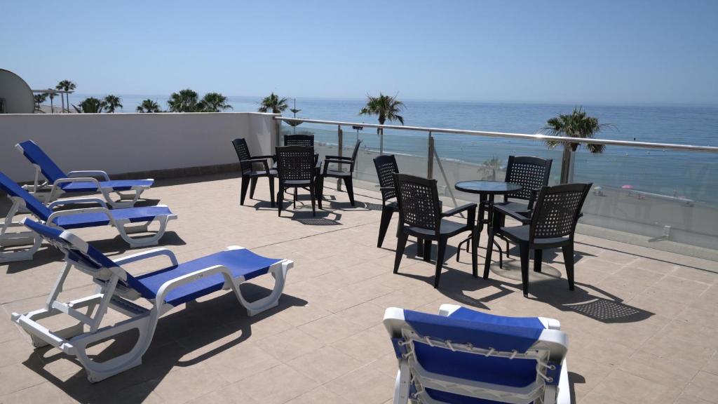 a group of chairs and tables and chairs on a balcony at As Apartamentos Turisticos in El Morche