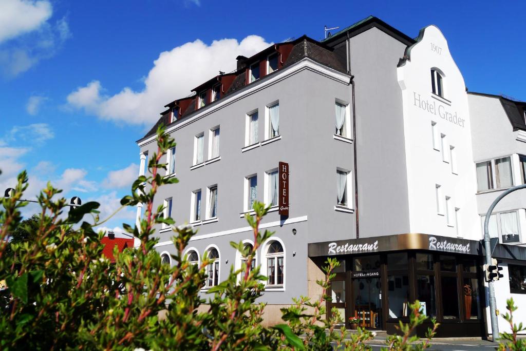 a white building with a black roof at Hotel Grader in Neustadt an der Waldnaab