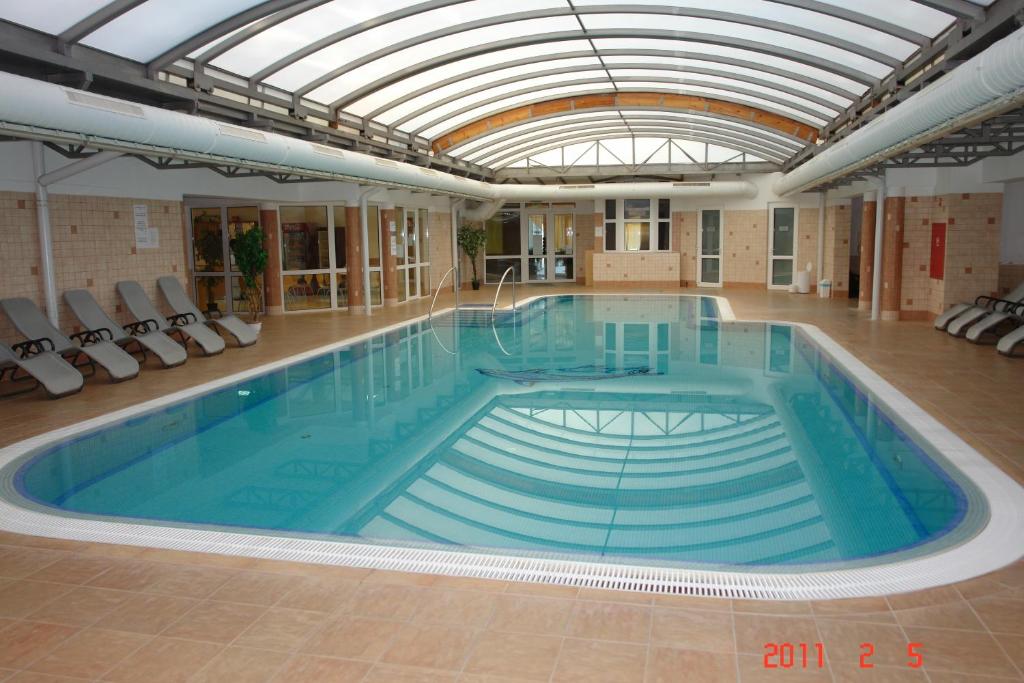 a large swimming pool with a glass ceiling at Lilla Wellnessapartman in Zalakaros