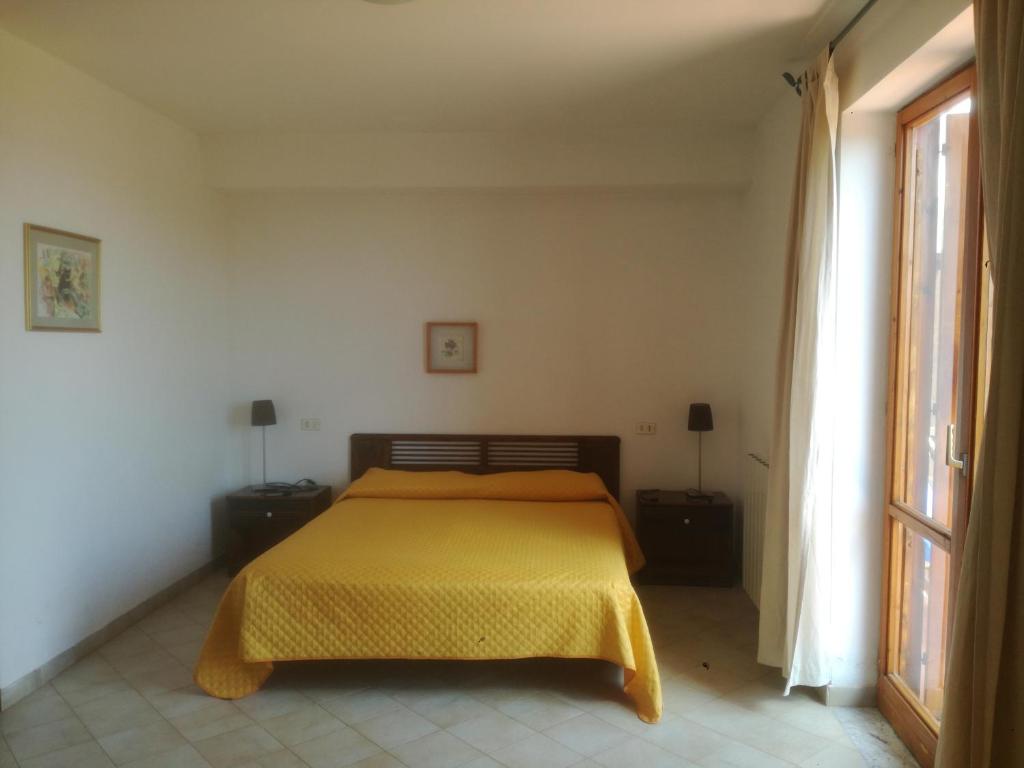 a bedroom with a bed with a yellow blanket at Casa de rosa in Palinuro