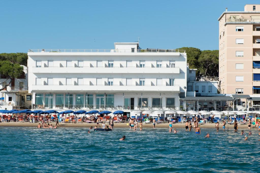 un groupe de personnes sur une plage dans l'eau dans l'établissement Hotel Parrini, à Follonica