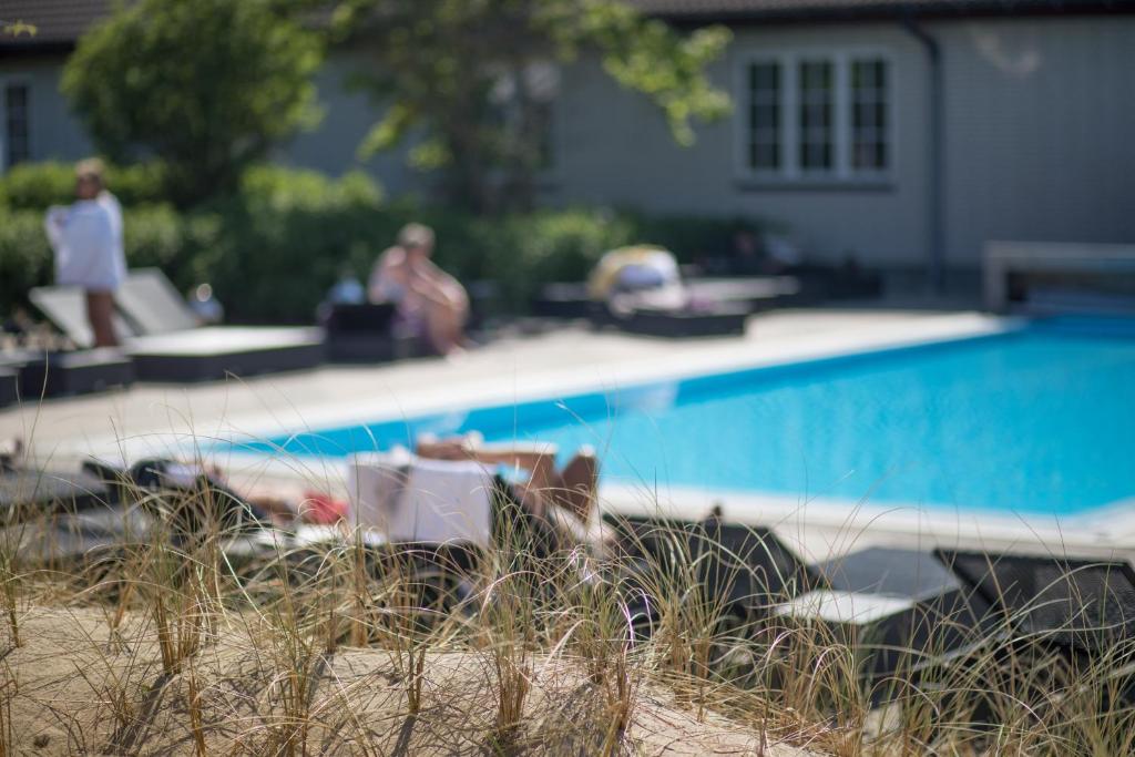 a swimming pool in front of a house at Color Hotel Skagen in Skagen