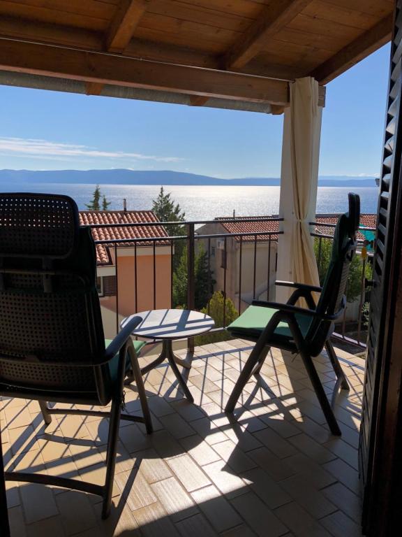 a patio with two chairs and a table on a balcony at Residence4a-Appartamento Verde in Ravni